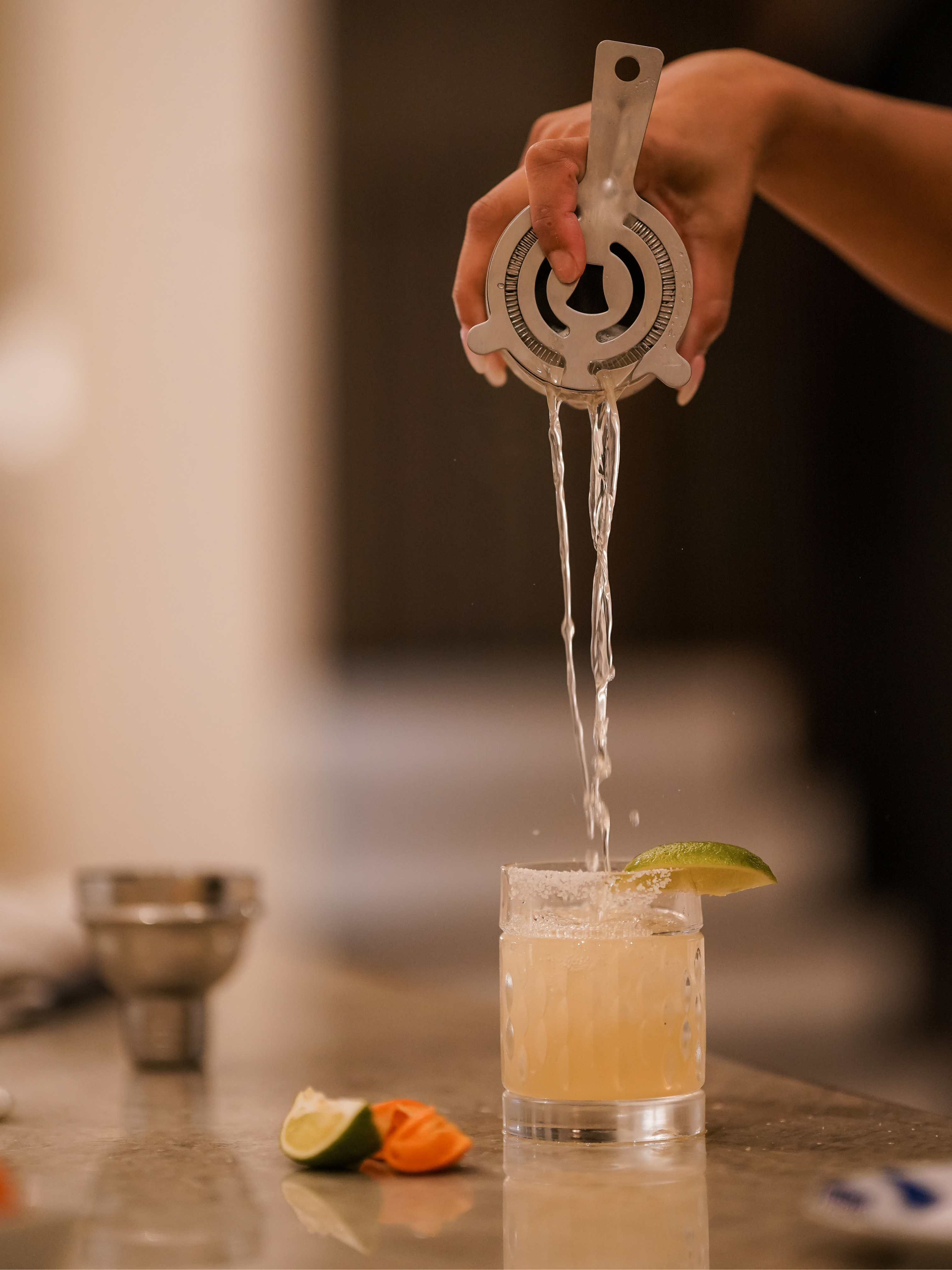 Close-up of a handcrafted cocktail being poured with a lime garnish, prepared by Polished Chef for a luxury private dining event in Dallas