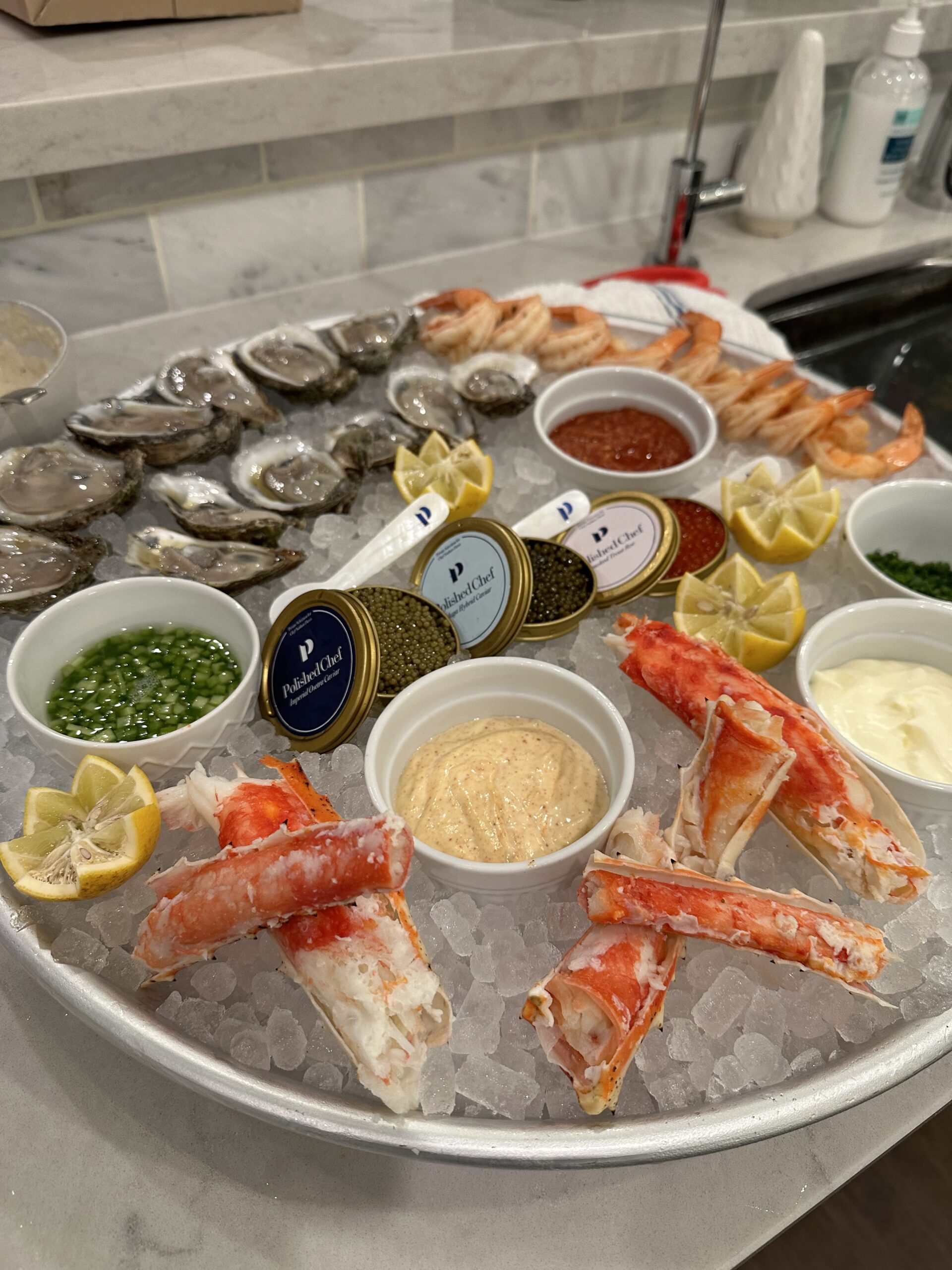 Dallas Polished Chef private-label caviar displayed on an elegant seafood platter with oysters, shrimp, king crab, and gourmet sauces