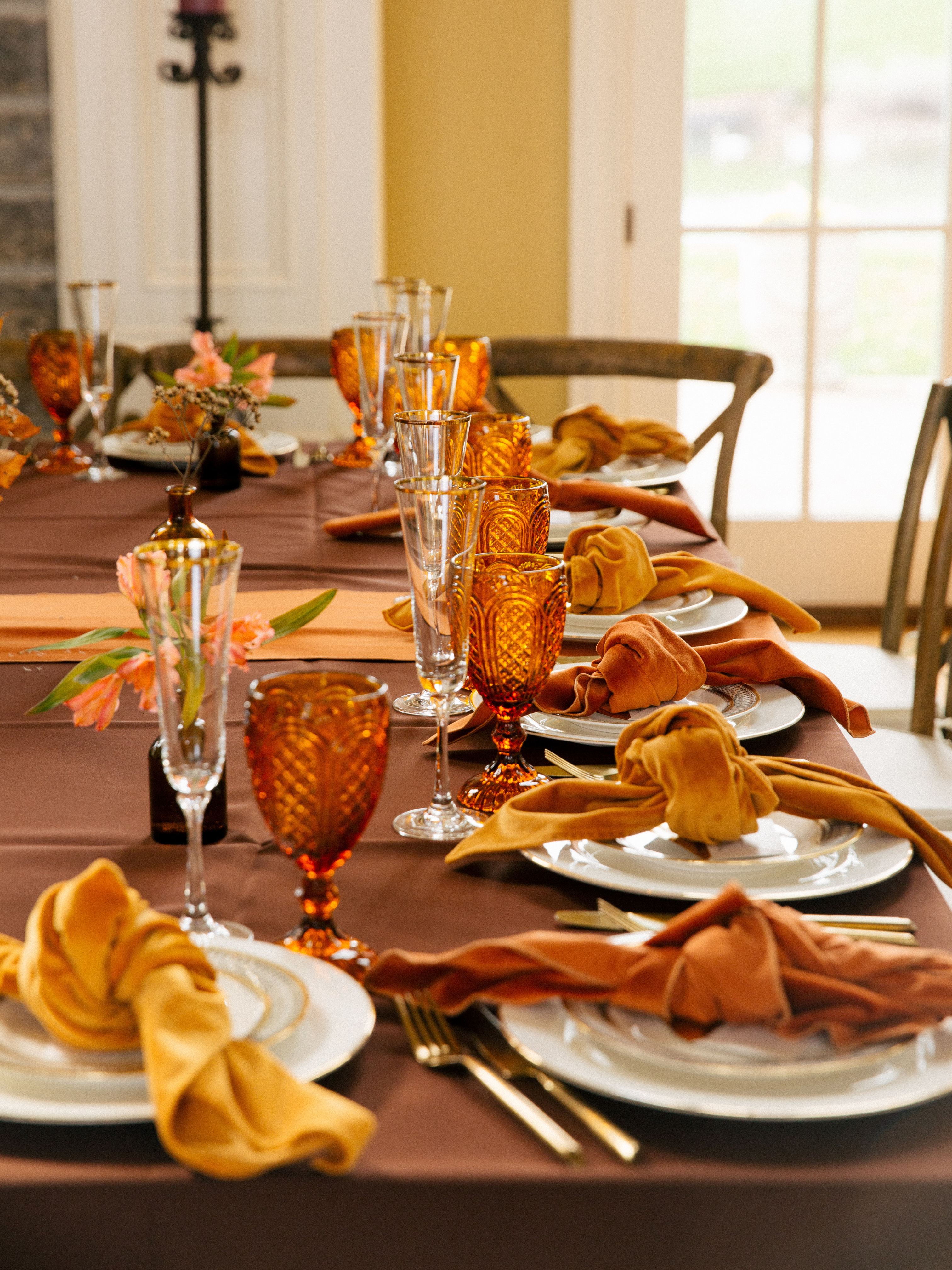 Beautifully arranged private dining table in Dallas by Polished Chef with golden napkins, amber glassware, and floral centerpieces for a luxury event